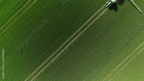 Aerial Top Down View of Tractor with Sprayer Working Green Field