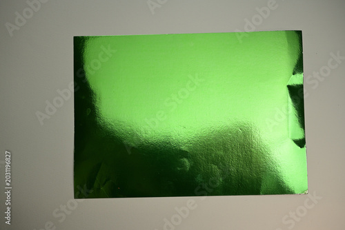 Green foil sheet metallic surface texture background. Reflective emerald paper template presenting abstract overlay creative graphic design projects corporate identity commercial luxury packaging mock