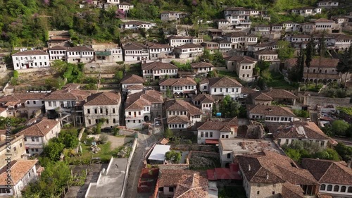 Drone Slow Tracking Right of Ancient Ottoman Houses with Red Roofs and Greenery in Berat