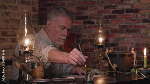 19th century man writing with a dip pen focus on lamp