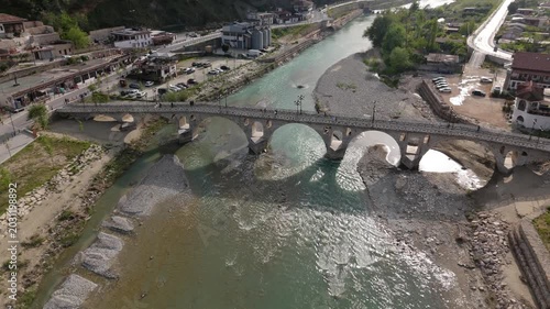 Drone Approach and Low Flyover of Historic Stone Gorica Bridge Over River in Berat