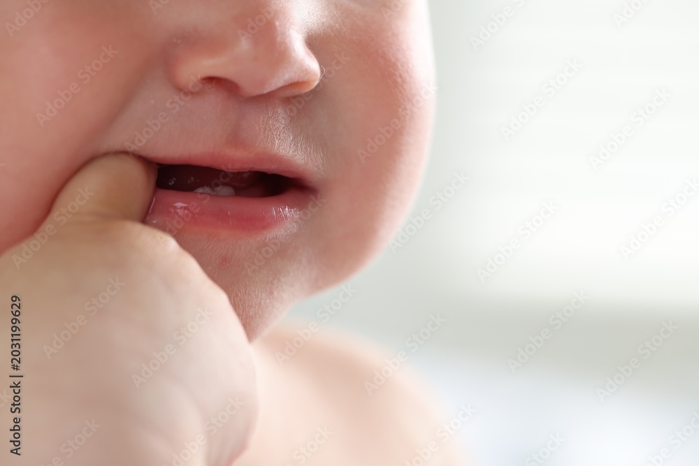 Fototapeta premium Cute child with first baby teeth indoors, closeup. Space for text