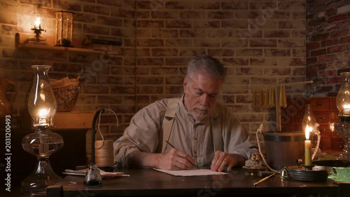 19th century man writing with a dip pen at his desk