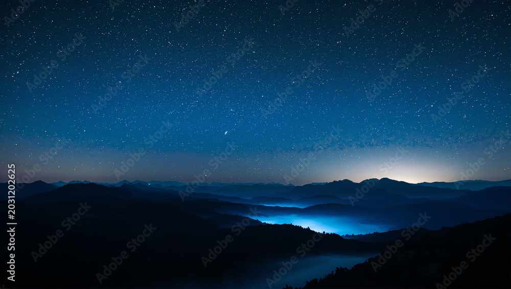 Fototapeta premium 星空と天の川の下で青い霧に沈む山脈の幻想的な夜景写真