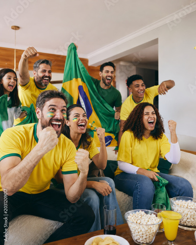 Torcedores brasileiros comemorando jogo de futebol em casa