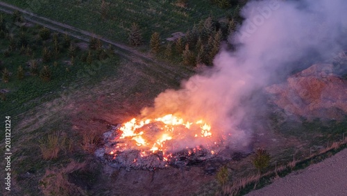 Fire of straw bale stack at night after ignition by flying ember aerial panorama of agricultural emergency situation
