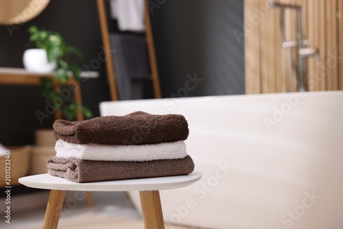 Bild auf Leinwand Soft towels on table near bathtub in bathroom, closeup