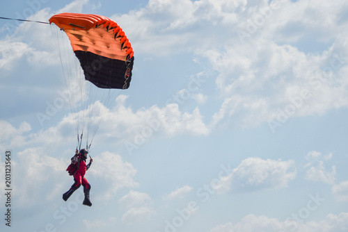 Foto Paraglider descending under bright green canopy against dramatic sky