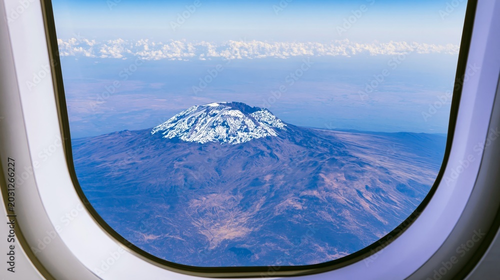 Fototapeta premium Majestic snow-capped Kilimanjaro mountain peak seen from airplane window
