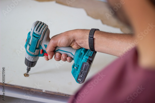 Fotografie Handyman using electric drill for home improvement project