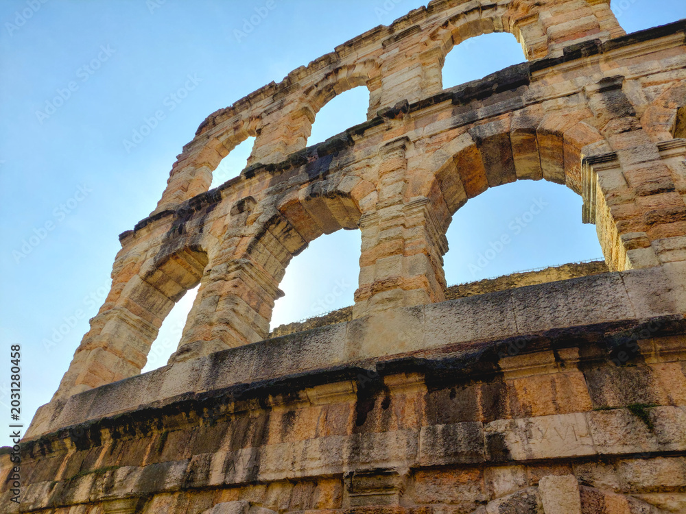 Obraz premium Detail of ancient stone arches in Roman style under a clear blue sky