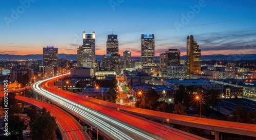 Cityscape at dusk with highway traffic.