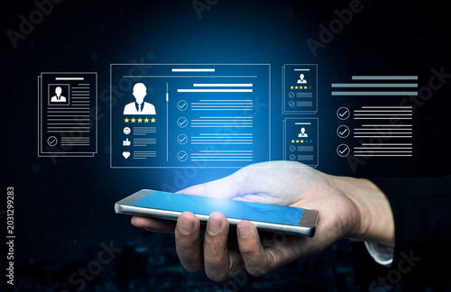 Tableau sur toile A hand holds a smartphone with a display of digital resumes and profiles, illustrating modern technology in recruitment and hiring processes through innovative graphics and data visualization