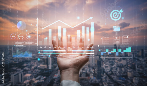 Fotografia Futuristic Business Analytics Concept with Hands Holding Digital Graphs and Charts Over City Skyline during Sunrise Haptic