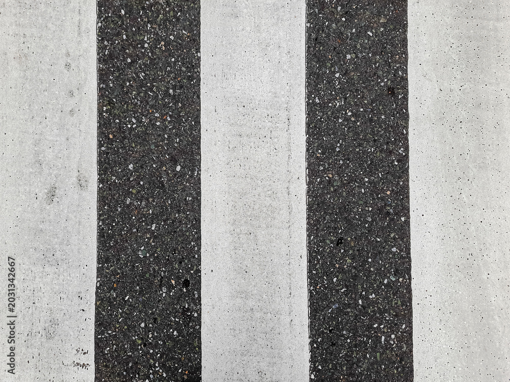 Fototapeta premium Crosswalk stripes contrast sharply against asphalt surface