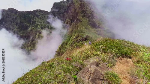 Scenic mountain peak with low-hanging fog and dramatic clouds moving through deep valleys.