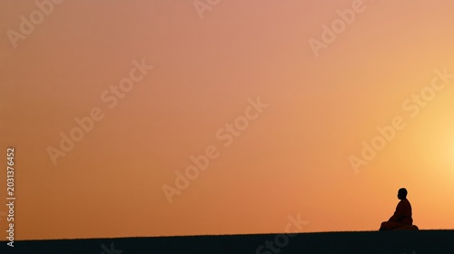 Buddhist monk meditating at sunset