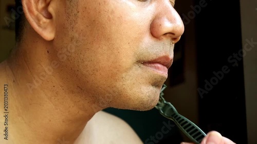 Person Shaving Face with Bright Green Razor in Domestic Bathroom