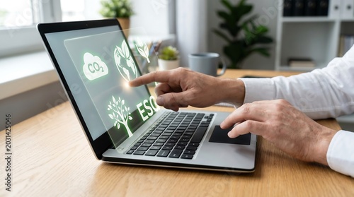 Businessman analyzing ESG data on laptop.