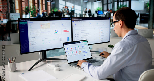 Photos Man Uses Laptop To Track Procurement Progress