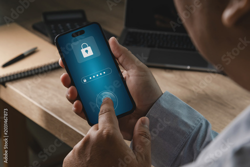 Photography Person using smartphone with password and fingerprint authentication interface in office workspace, suitable for banking security, payment protection, account recovery, and digital privacy concepts