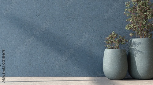 Two contemporary textured planters containing small trees stand against a deep blue textured wall surface