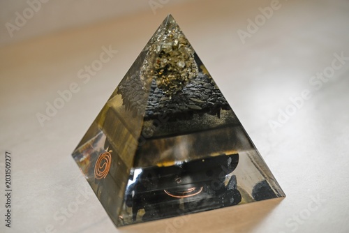 Handmade Orgone Pyramid with Pyrite Crystal and Obsidian Layers – Unique Black and Gold Energy Pyramid with Circular Metal Geometry, Close-Up Isolated on White Background