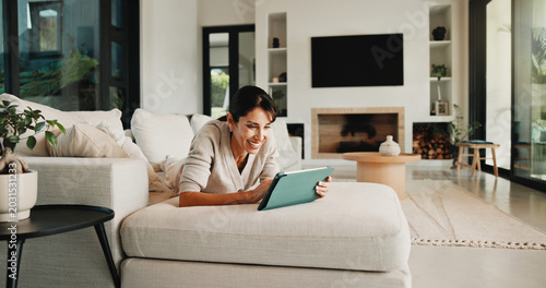 Photos Streaming, relax and woman on couch with tablet, movie binge and video watching on digital app