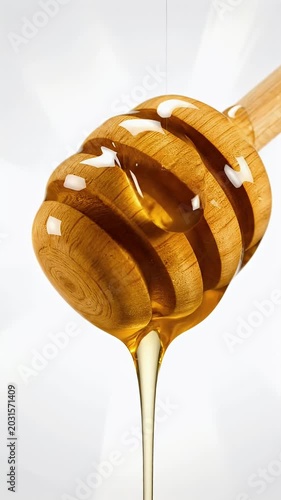 Golden Honey Dripping From Wooden Dipper Against A White Background With Radial Light Effect