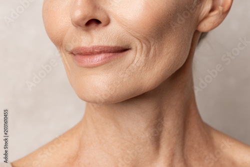 Visible facial wrinkles and skin aging are shown by a Caucasian middle-aged woman with fair skin in a close-up macro portrait.
