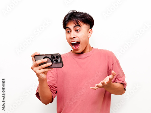 Fotografija Shocked young Asian man looking at smartphone with open mouth reacting to unexpe