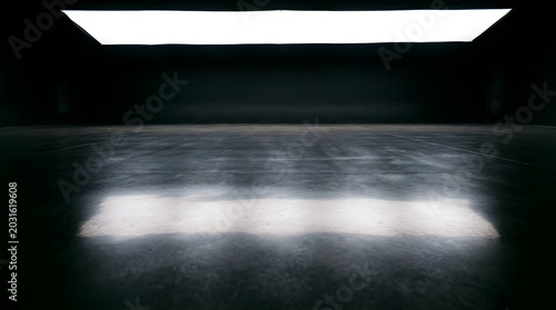 Spotlight illuminates mist or smoke on a dark concrete floor in an empty
