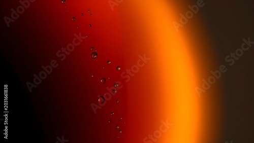 Close-up gradient of dark brown and amber liquid with tiny rising bubbles.
