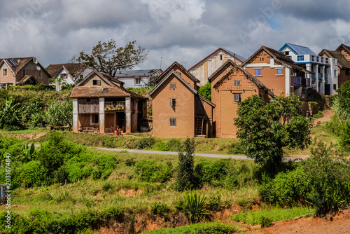 Obraz na płótnie Traditional brick houses in the Madagascar highlands situated on a lush green hi