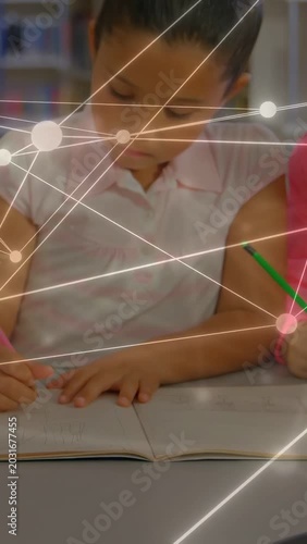 Vertical video: Two girls writing in school, studying with page turning, glowing network over pages