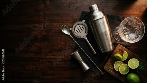 Professional Cocktail Bar Tools and Fresh Limes on Dark Wood Table