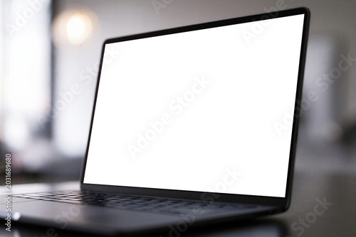 Modern laptop with blank screen on a desk in a blurred office interior