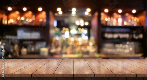 Empty wooden table top with lights bokeh on blur restaurant background.