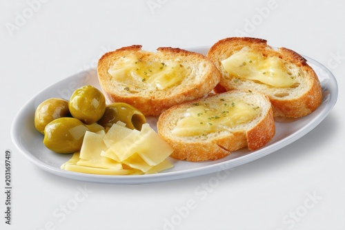 Toasted bread slices with cheese and olives arranged on a white plate