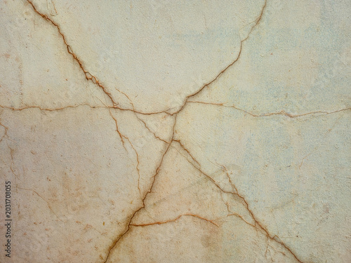 Cracked concrete wall background with texture, damaged stucco surface with deep fractures, close-up of old weathered cement wall backdrop for design