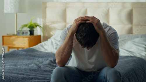Photos Worried tired Caucasian man sitting bed home holding head stressed male in bedro