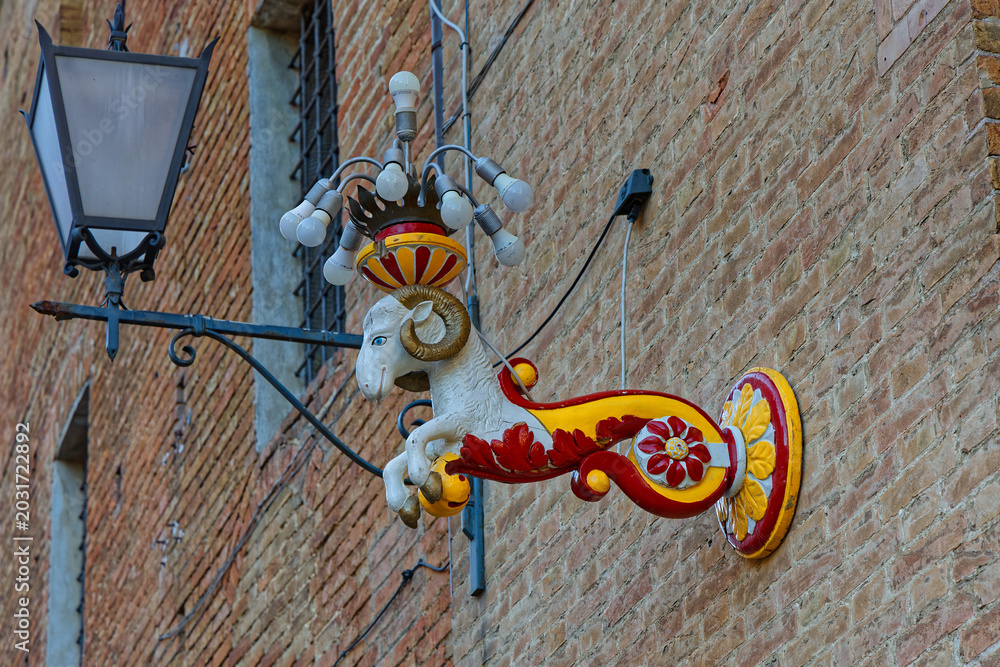 Fototapeta premium SIENA, ITALY, April 24, 2026 : Street colored ram decoration in the streets of old city