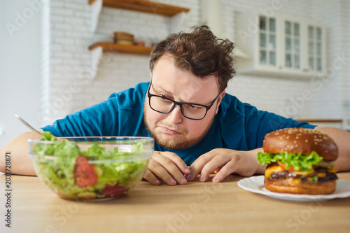 Fotografi Overweight man faces burger and salad choice