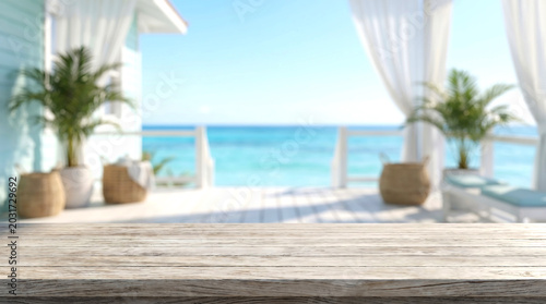 Wooden Table Top Surface with Blurred Beach Resort Porch and White Curtains for Summer Product Mockup Display