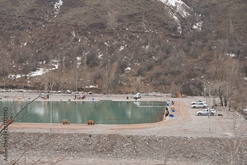 Fishermen angling on the shores of a trout pond in Issyk Gorge