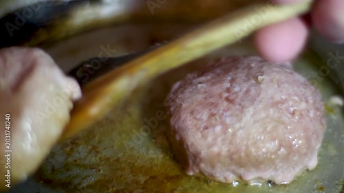 Fresh pork medallions frying in hot oil in a metal pan