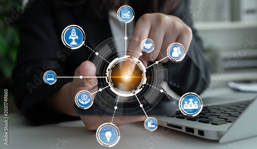 Obraz na płótnie A business professional engages with a digital interface, showcasing various symbols of technology and analytics, emphasizing growth and innovative strategies in the workplace
