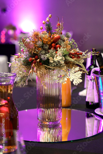 Photos Elegant Christmas floral centerpiece in glass vase on festive event table with p