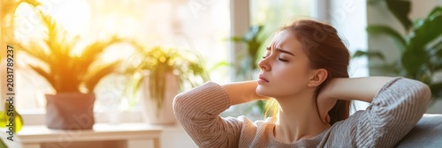 Tired woman massages her neck at home to ease pain and tension, seeking relief from stress and discomfort in an indoor setting