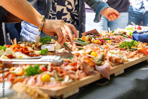 Fotografie Buffet traiteur avec planches de charcuterie, fromages et tapas lors d’un événement convivial en extérieur